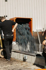 a man standing next to a machine making something blue