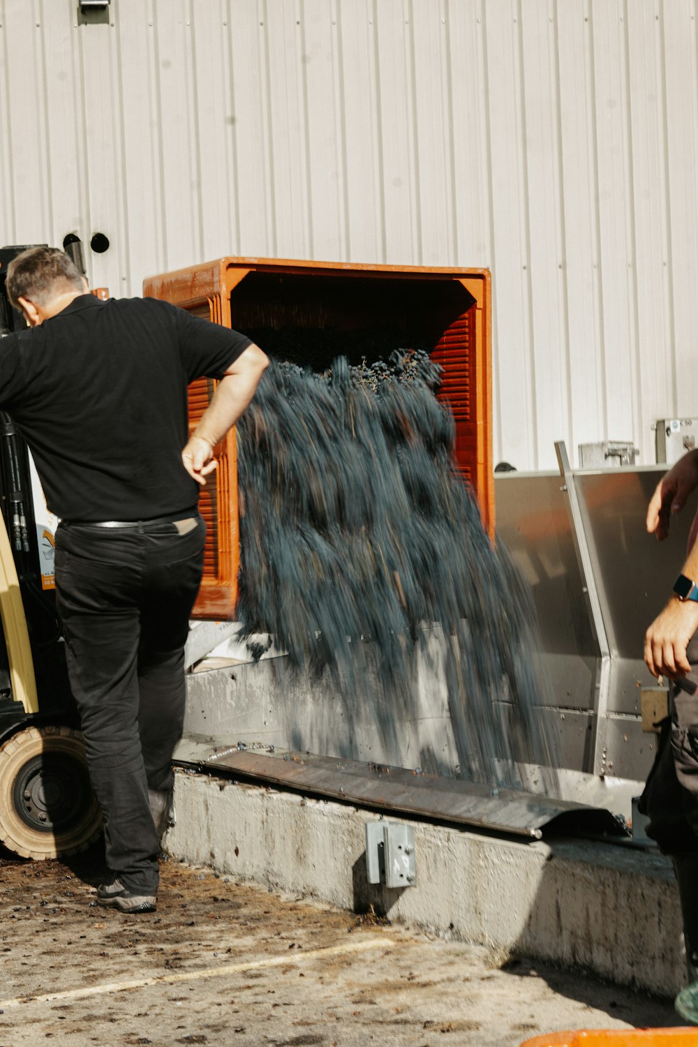 a man standing next to a machine making something blue