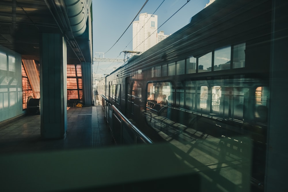 a train traveling down train tracks next to a tall building