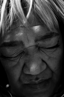 Close-up portrait of a weathered face, eyes full of stories, shot in monochrome.