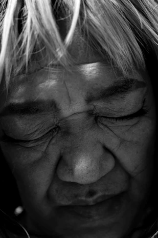 Close-up portrait of a weathered face, eyes full of stories, shot in monochrome.