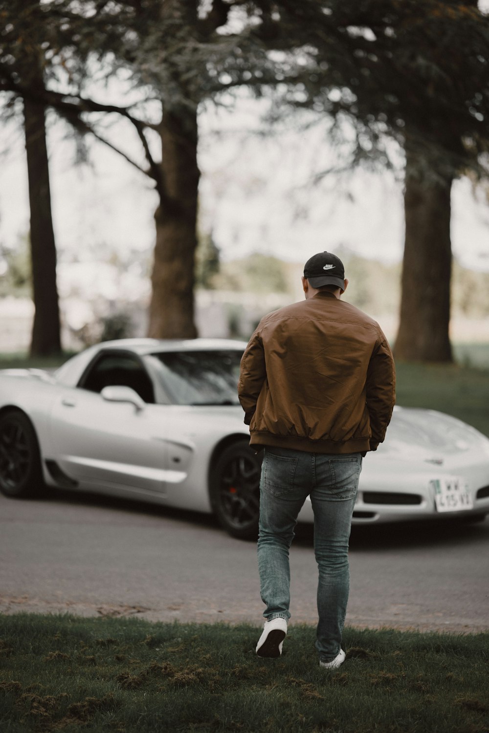 a man standing in front of a white sports car