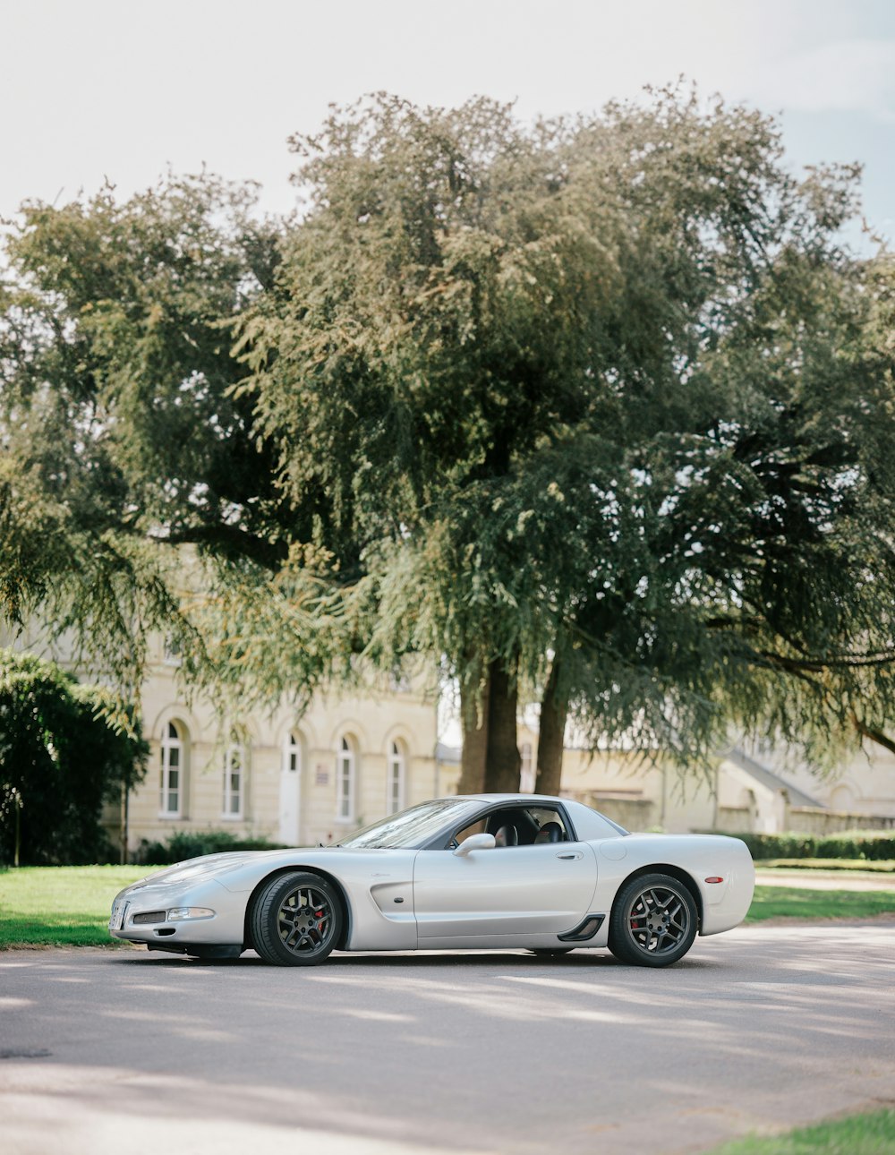 a silver sports car parked on the side of the road