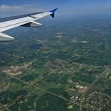 A warm aerial view of flat rural land in Ñiñue, Maule, with clear skies and visible lot boundaries.