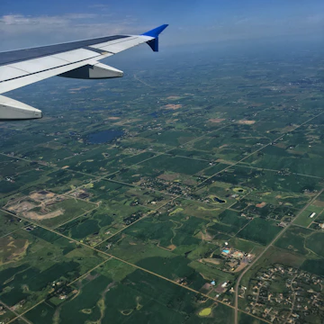 A warm aerial view of flat rural land in Ñiñue, Maule, with clear skies and visible lot boundaries.