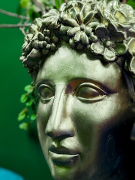 Close-up of a finely detailed 3D printed decorative sculpture blending green and gold tones.