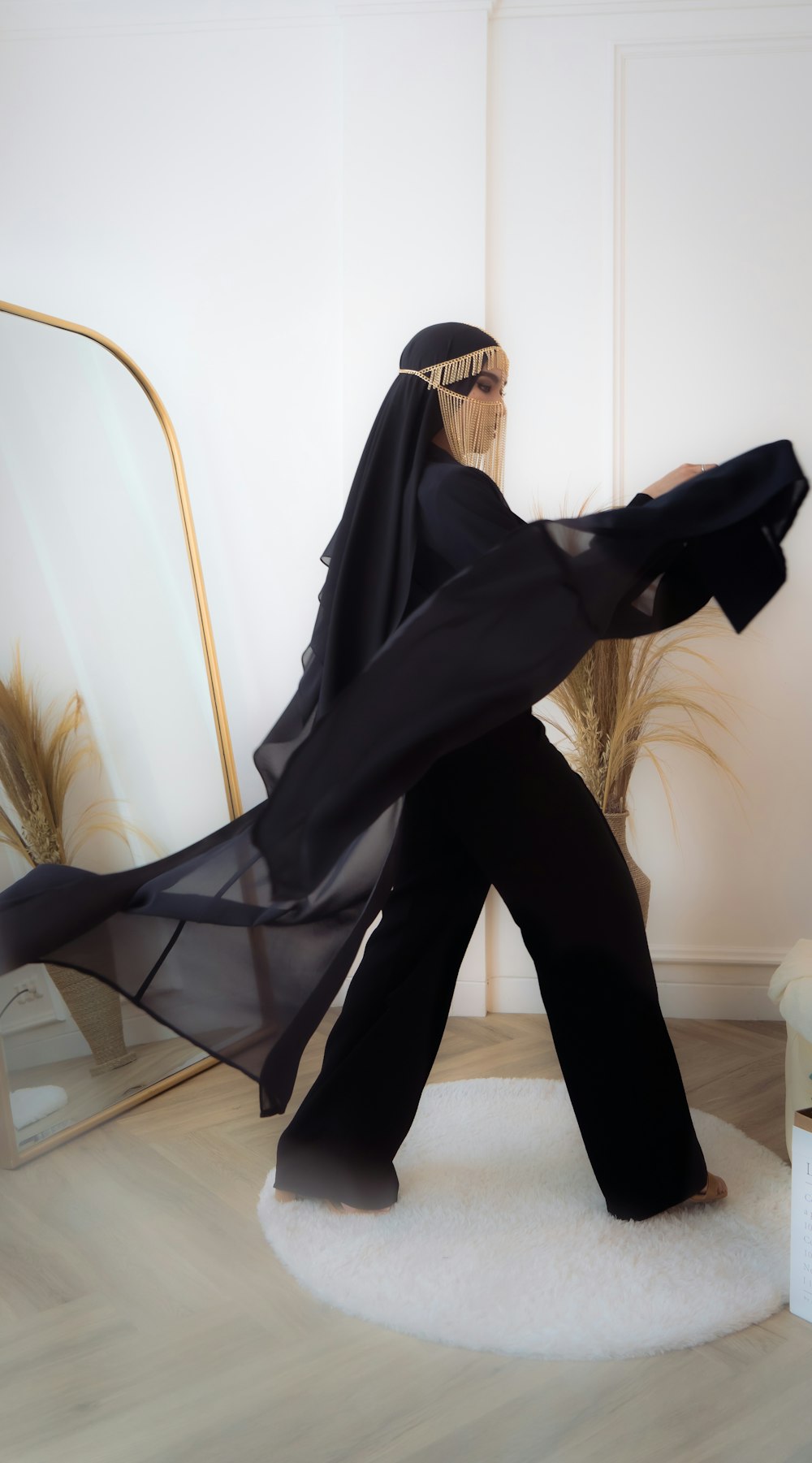 a woman in a black outfit standing on a white rug