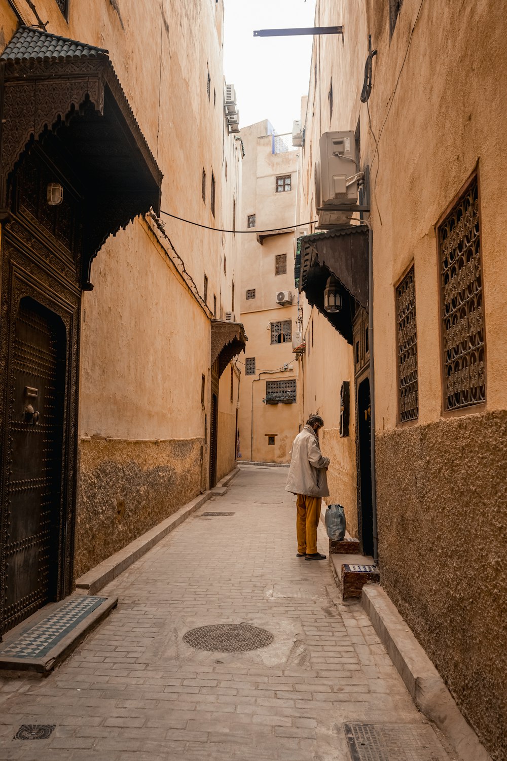 a man standing in an alley between two buildings