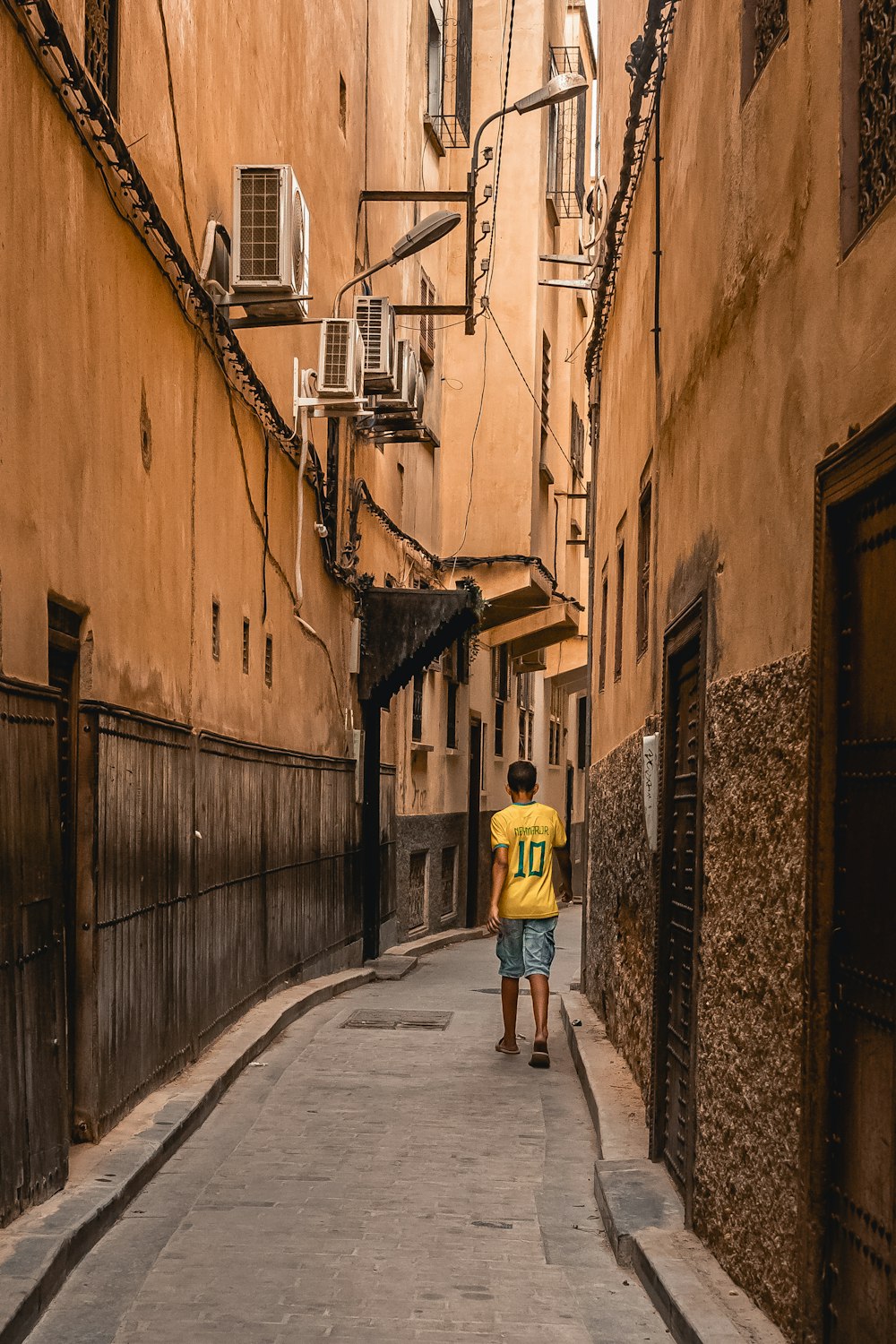 a man walking down a narrow alley way