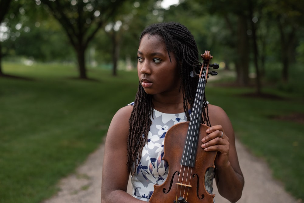 a woman with dreadlocks holding a violin