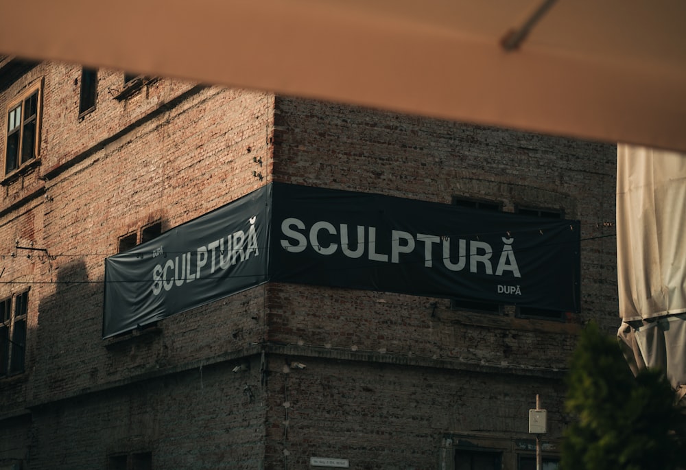 a brick building with a sign that says sculptura on it