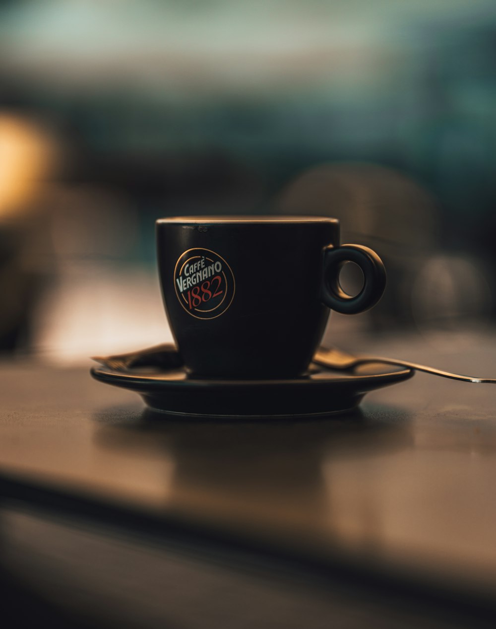 a cup of coffee sitting on top of a wooden table