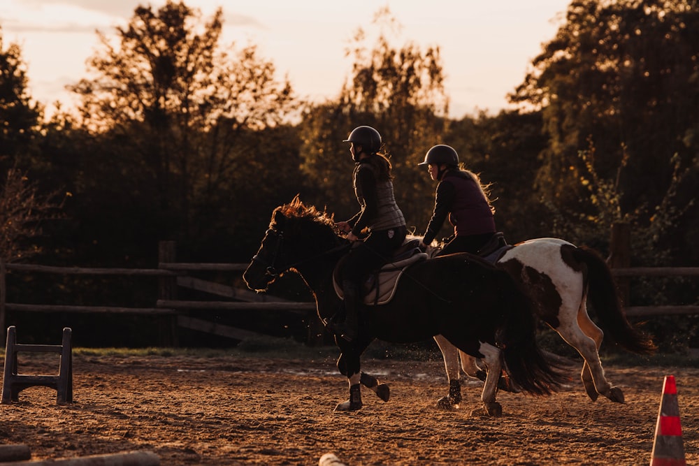 a couple of people riding on the back of horses