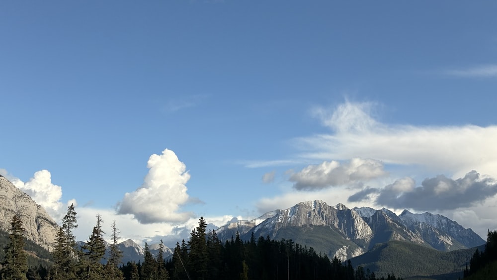 a scenic view of a mountain range with clouds in the sky