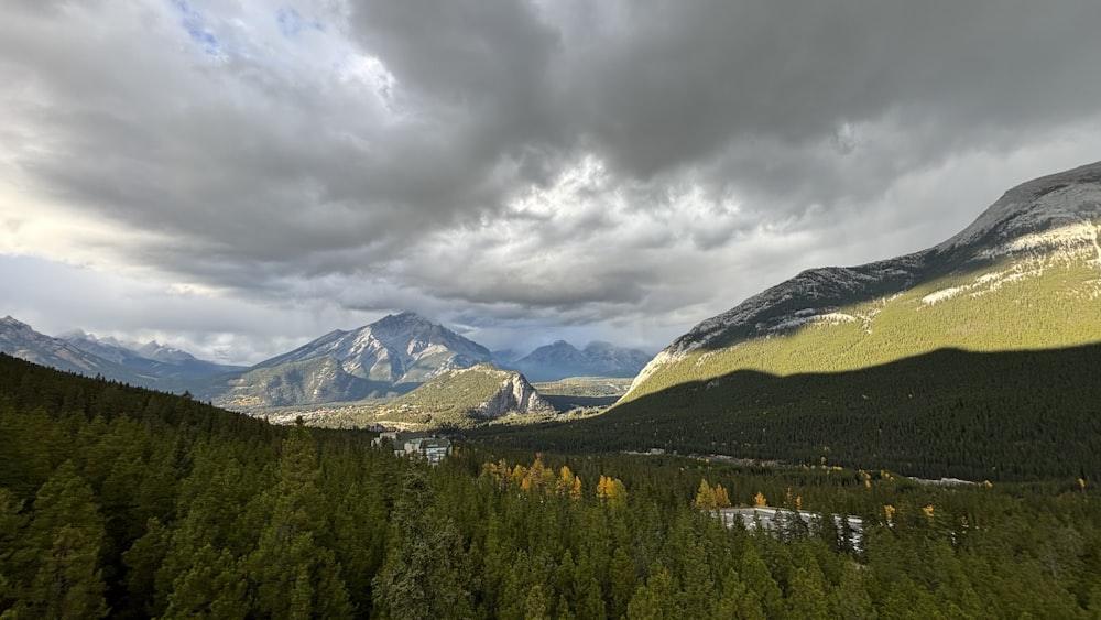 a view of a mountain range with trees and mountains in the background