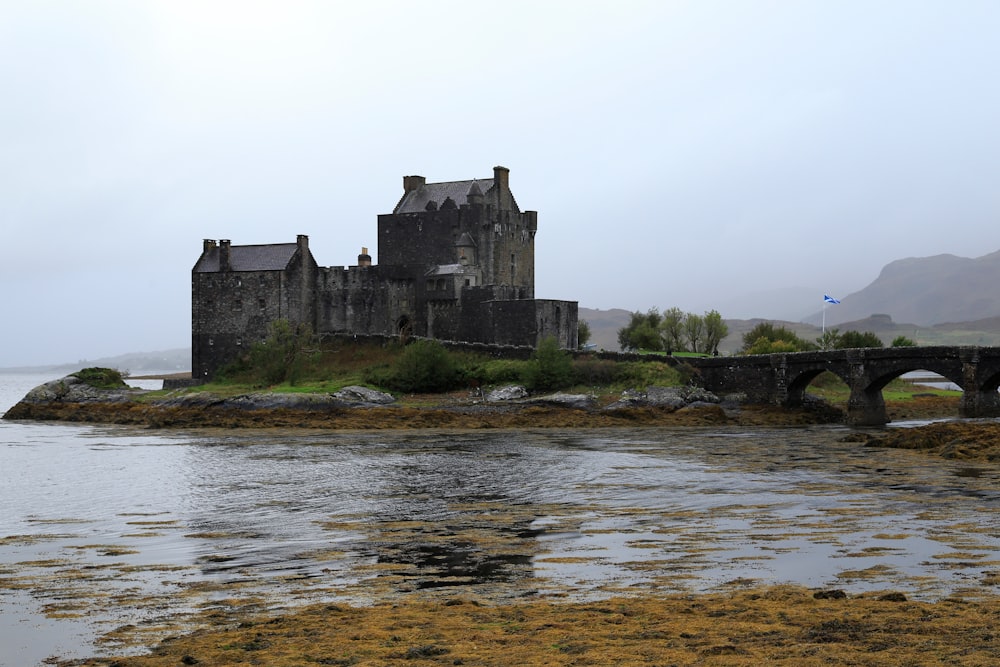 a castle sitting on top of a small island next to a body of water