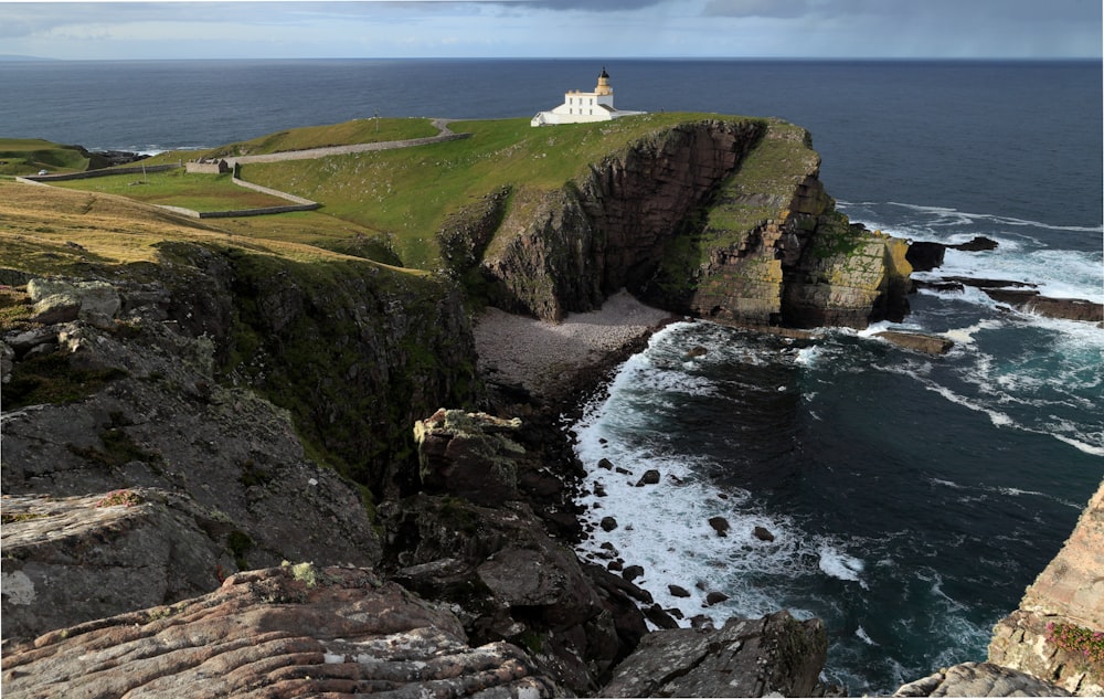 a lighthouse on top of a cliff near the ocean