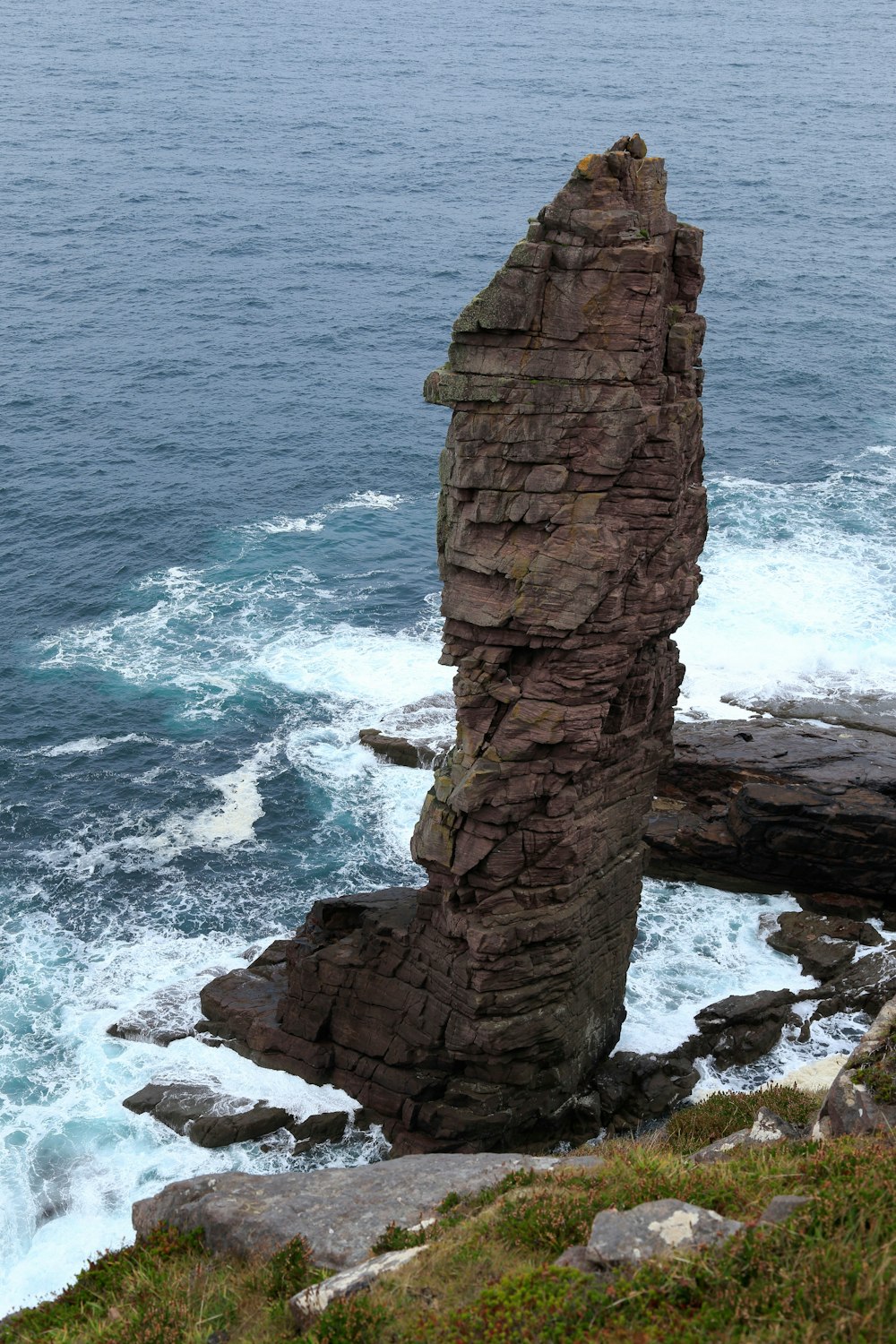 a large rock sticking out of the ocean