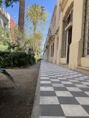 Wide, clean concrete sidewalk running alongside a retail storefront in Panama City.