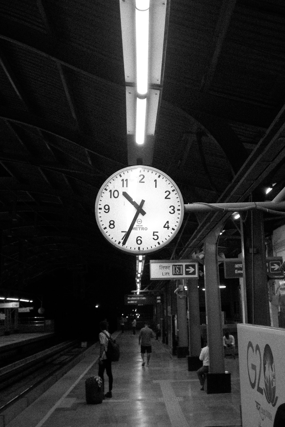 Una foto en blanco y negro de un reloj en una estación de tren