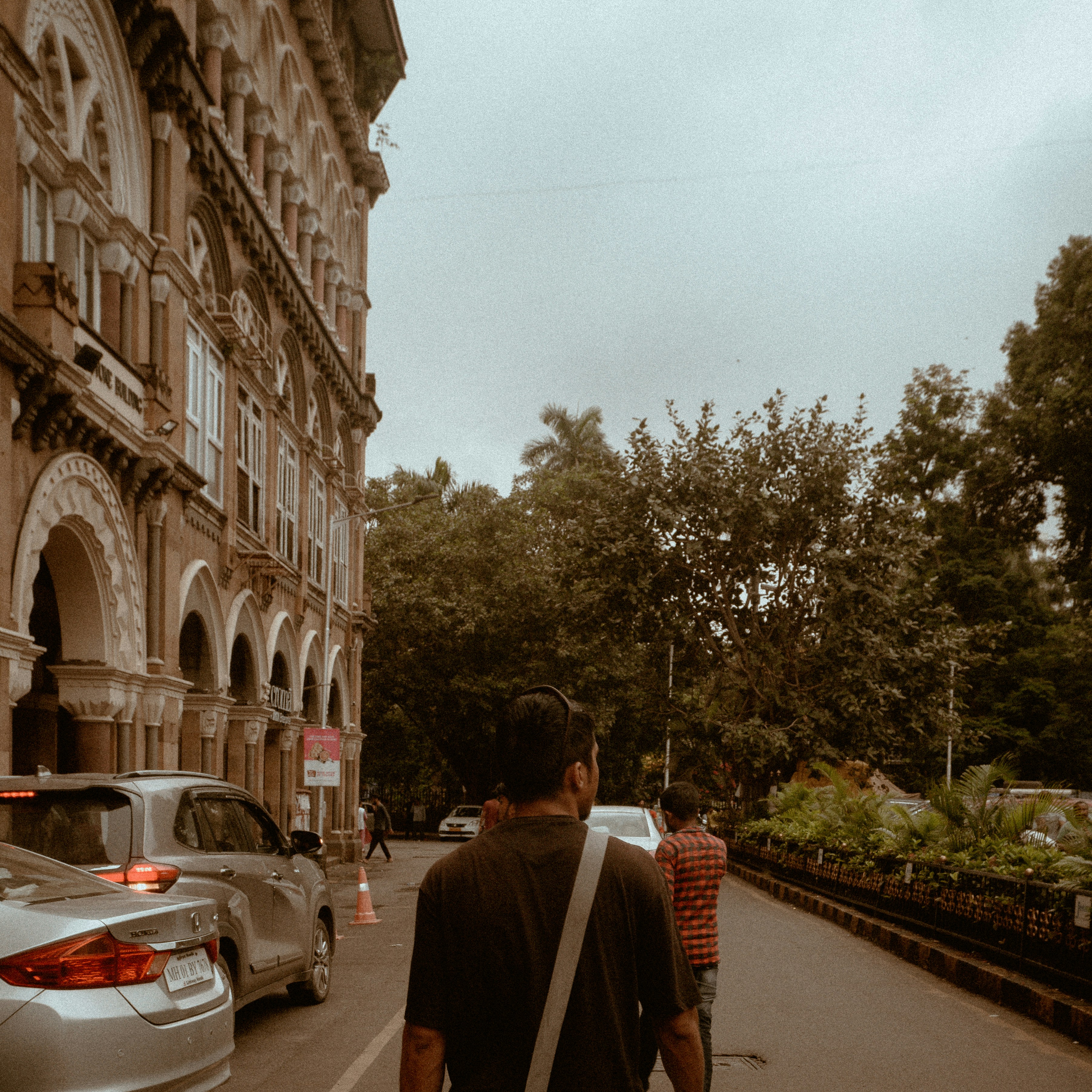 Un hombre caminando por una calle al lado de un edificio alto