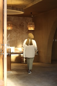 Lifestyle photo of a sophisticated muslimah woman wearing marlei, walking softly through a sunlit minimalist interior.
