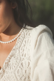 Close-up of a model wearing a delicate knit top in muted pastel tones, highlighting the texture and softness.
