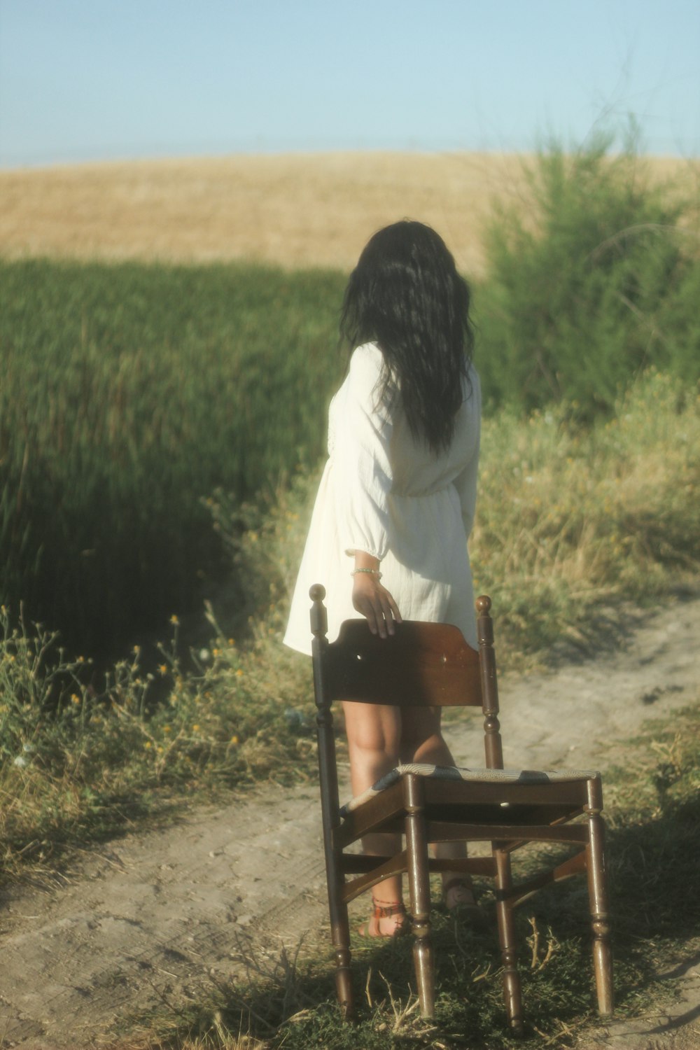 a girl sitting on a chair in a field