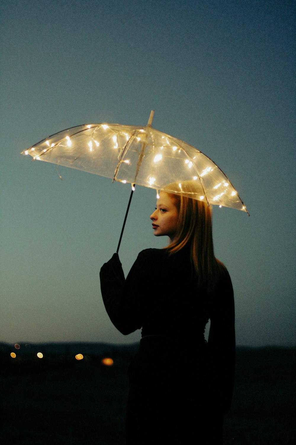 a woman holding an umbrella with lights on it