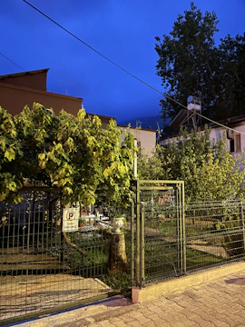 A wide shot of a backyard fenced with black metal panels, showing a peaceful, private outdoor space.