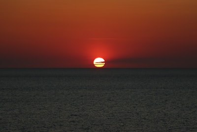 A vibrant sunset over the Red Sea coastline near Jizan, capturing the warm hues and calm waters.