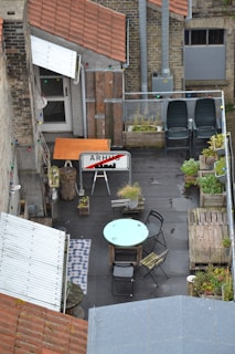 A rooftop patio with artificial turf flooring, cozy seating, and potted plants creating a relaxing space.