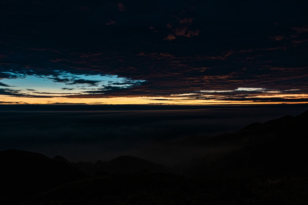 a view of the sky and clouds from the top of a mountain