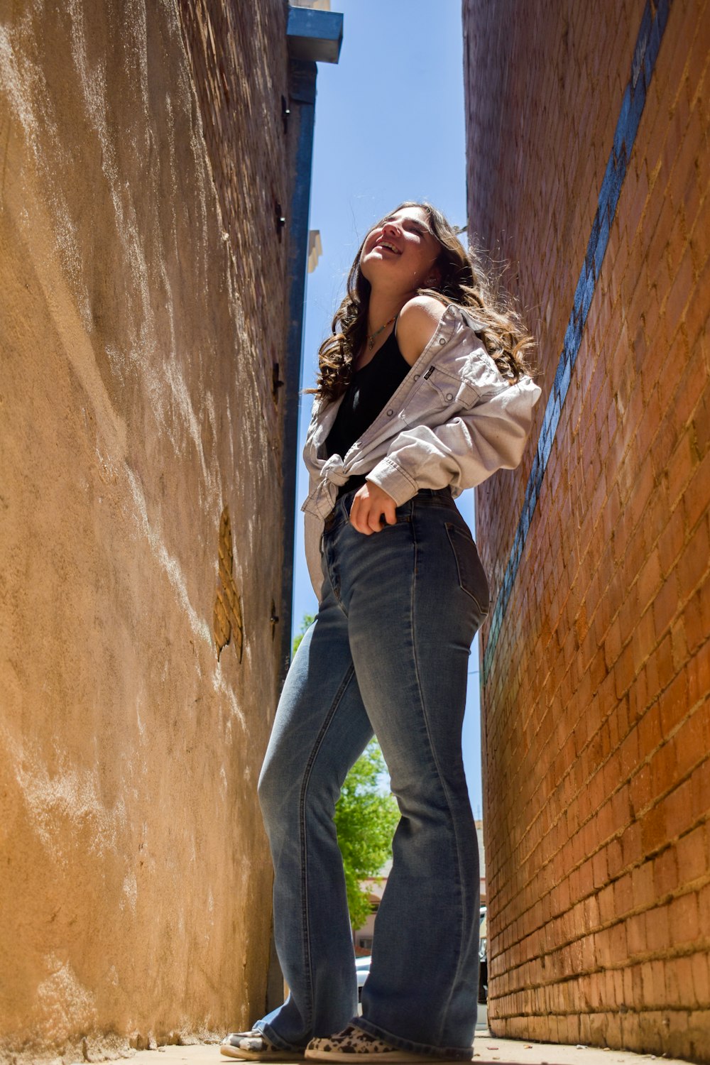 a woman standing in a narrow alley way