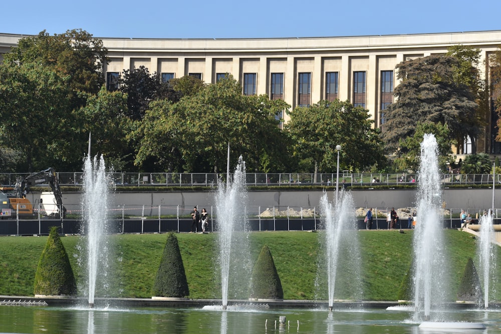 a group of water fountains in front of a building