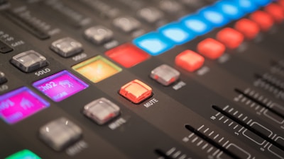 Close-up of mixing console with colorful lights glowing during an audio session.