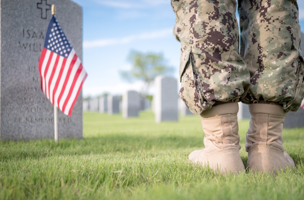 a soldier's legs and boots in front of a grave