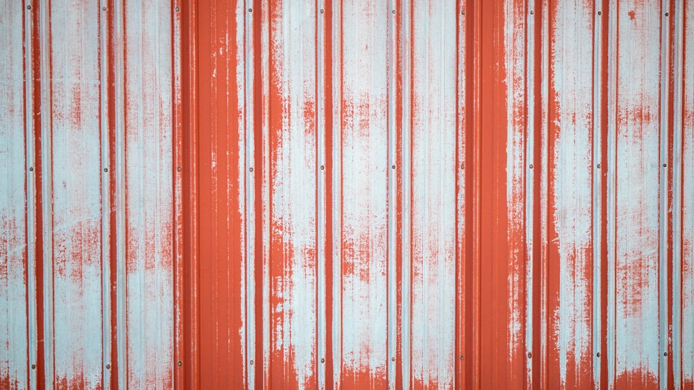a red and white striped wall with some rust on it