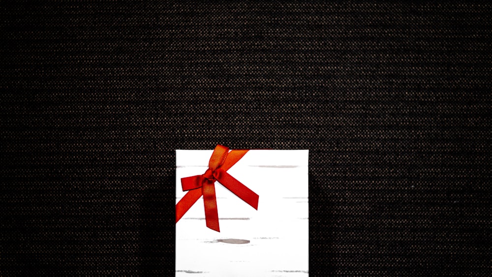 a piece of paper with a red bow on it