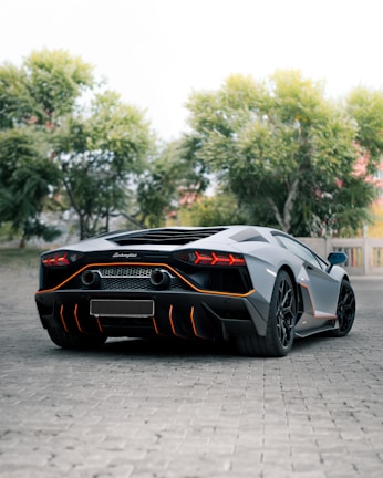 a grey and orange sports car parked in a parking lot