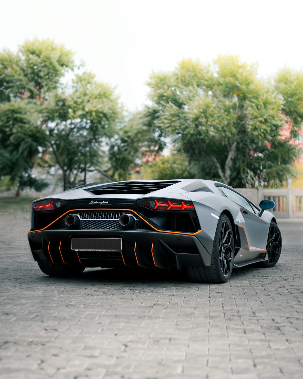 a grey and orange sports car parked in a parking lot