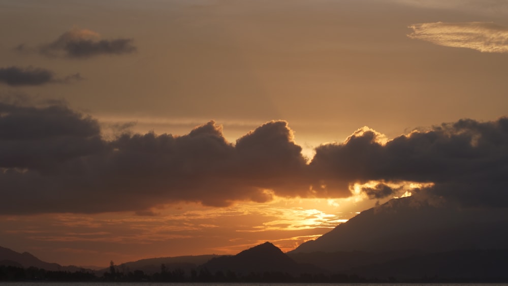 the sun is setting over a mountain range