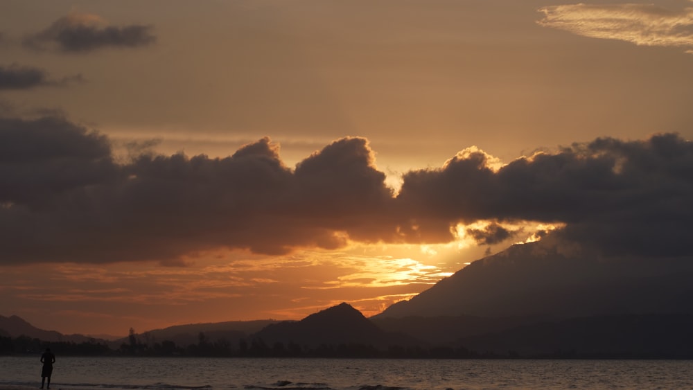 a person standing on a beach at sunset