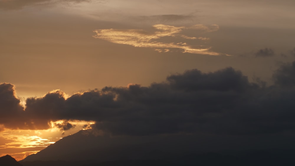 the sun is setting behind the clouds in the sky