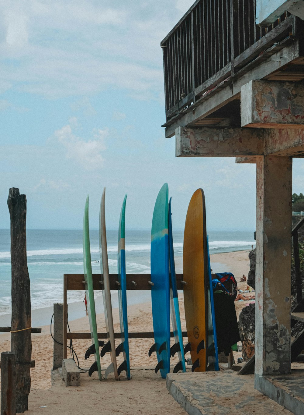 un grupo de tablas de surf sentadas en la parte superior de una playa de arena