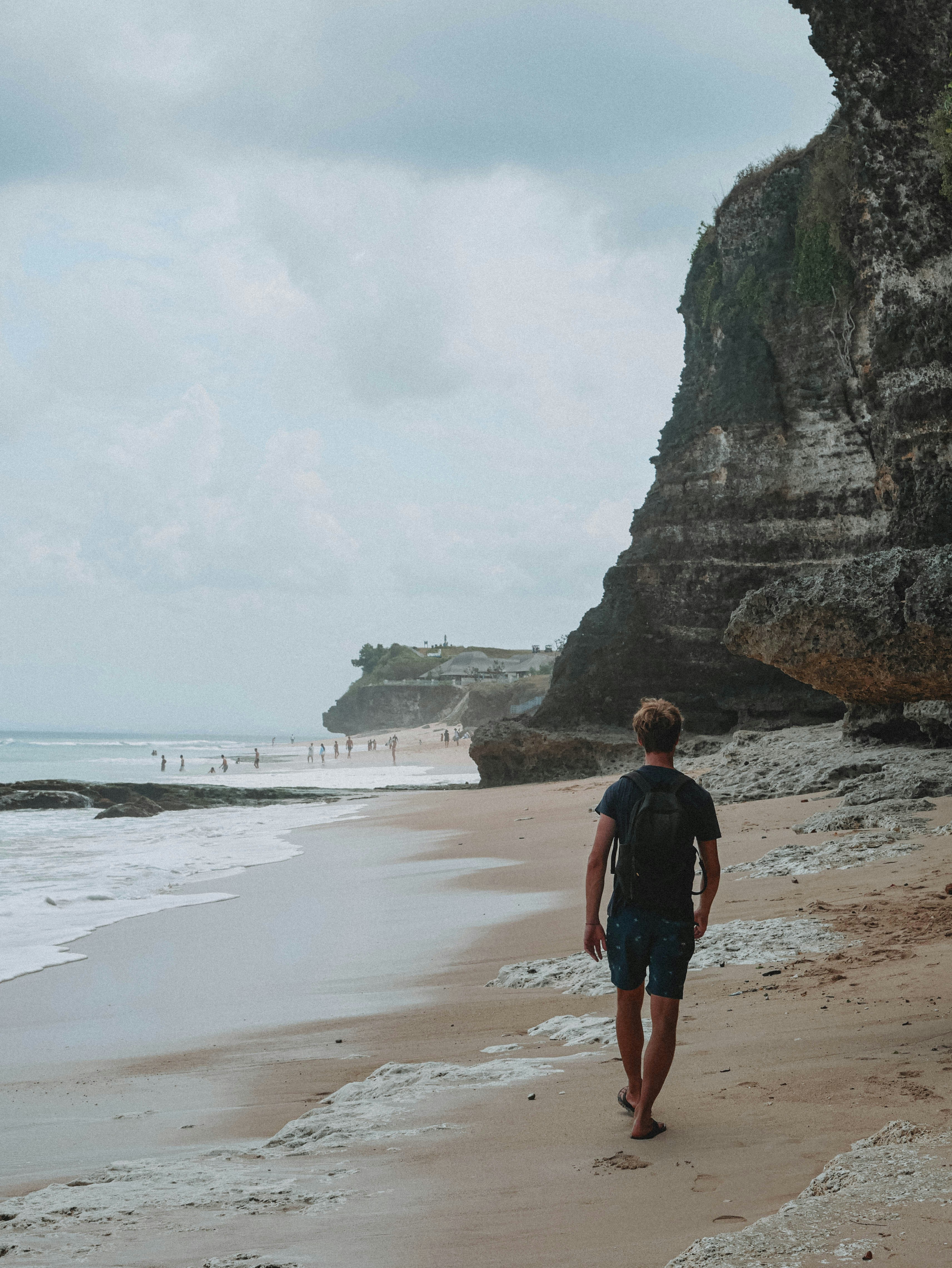 Un homme marchant le long d’une plage au bord de l’océan