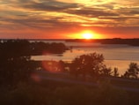 A serene landscape featuring a sunset over a tranquil lake.