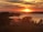 A serene landscape with a sunset over a calm lake.
