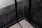 a corner of a window with rain drops on it