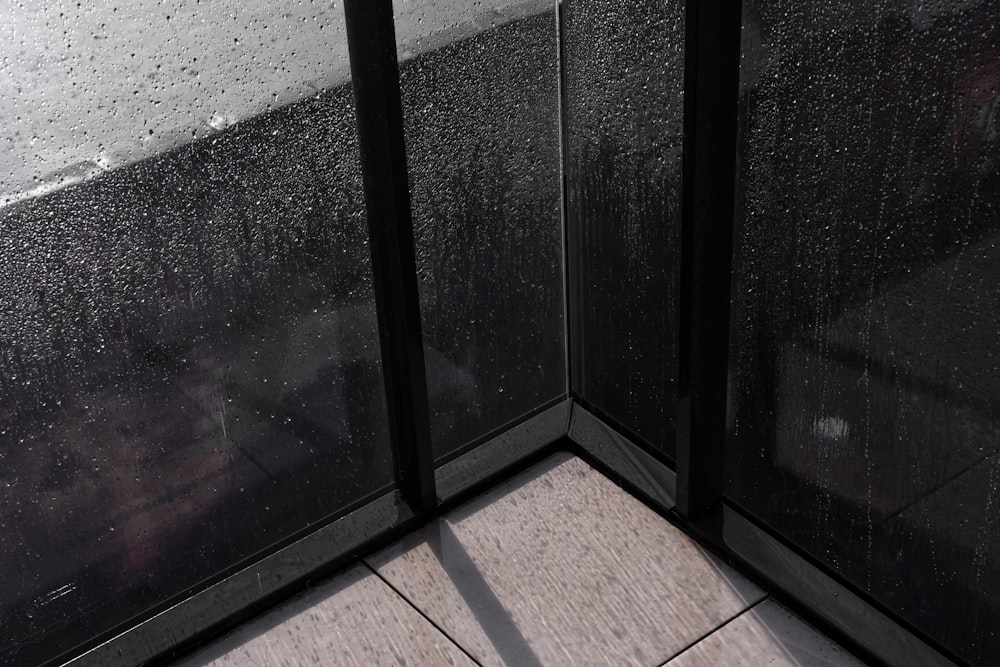 a corner of a window with rain drops on it